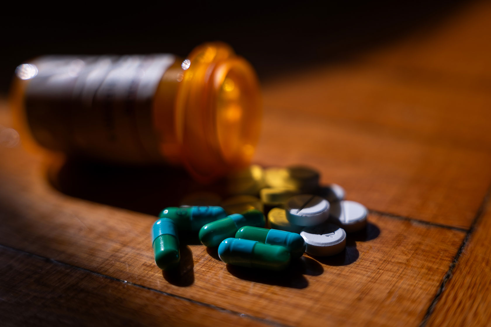 Pills next to an orange prescription bottle