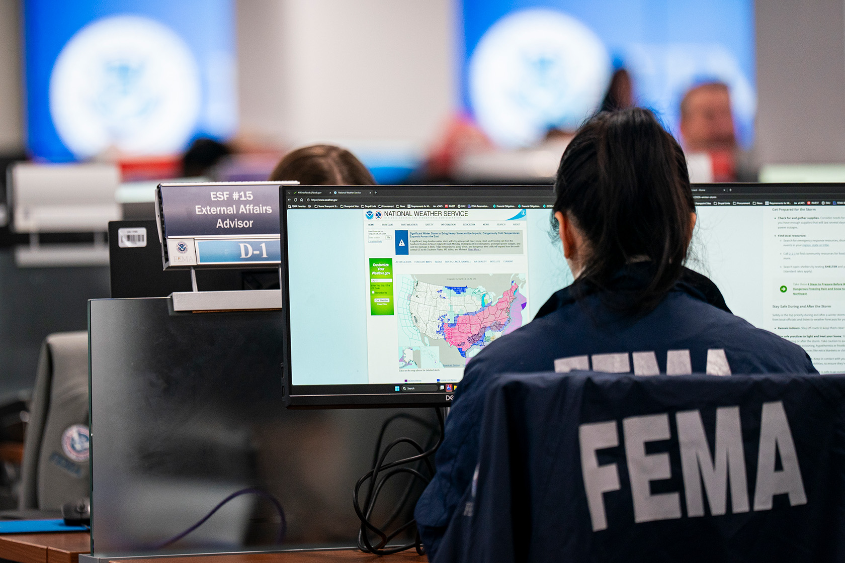 A worker in FEMA’s National Response Coordination Center looks at a map of an approaching winter storm.