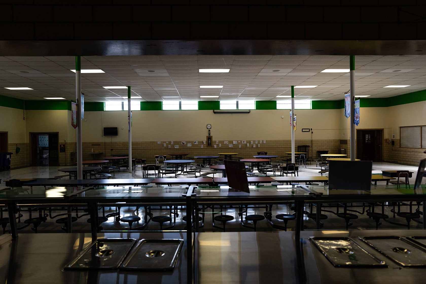 View of cafeteria from behind serving counter, in low lighting